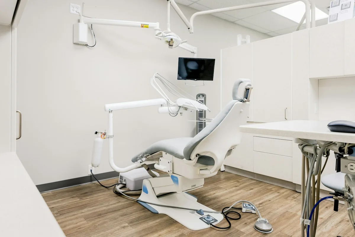 Consultorio odontológico con sillón, lámpara e instrumental ordenado